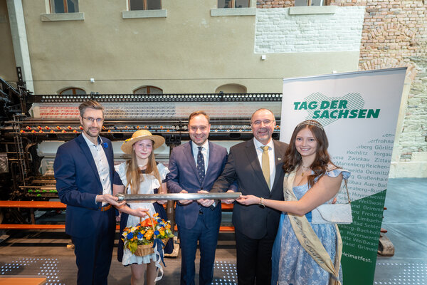 Der Sebnitzer Oberbürgermeister Ronald Kretzschmar übergibt den Staffelstab zusammen mit dem Blumenmädchen und Landtagspräsident Alexander Dierks an Plauens OB Steffen Zenner und die Spitzenprinzessin (v.l.n.r.) 