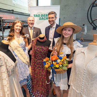 Bild vergr&ouml;&szlig;ern: Spitzenprinzessin Maxi Schulz, Plauens Oberbürgermeister Steffen Zenner, der Sebnitzer Oberbürgermeister Ronald Kretzschmar und Blumenmädchen Jolien Kirschner (v.l.n.r.) in der Fabrik der Fäden